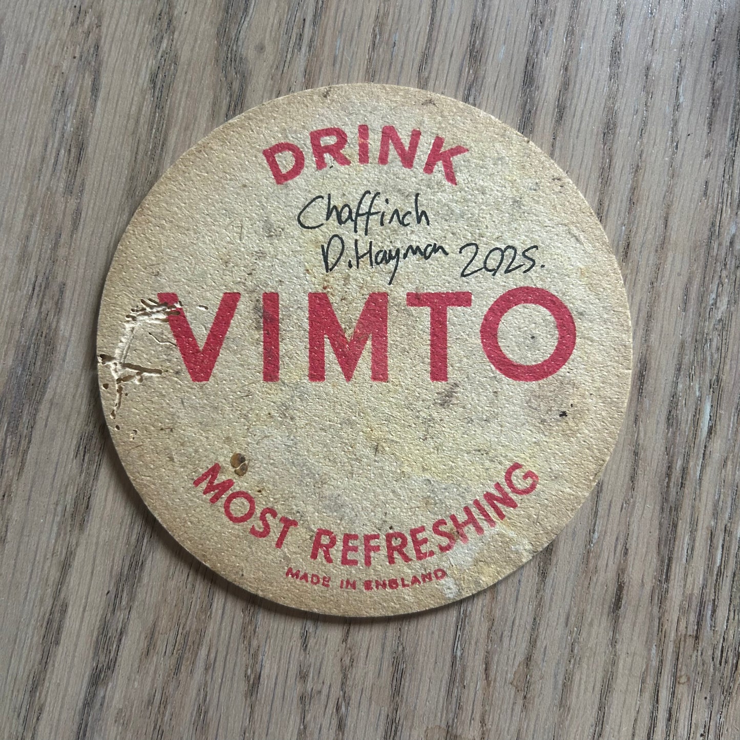 A Chaffinch painted onto a Vimto drinks mat from the 1950s. Beermat painting. Watercolour.
