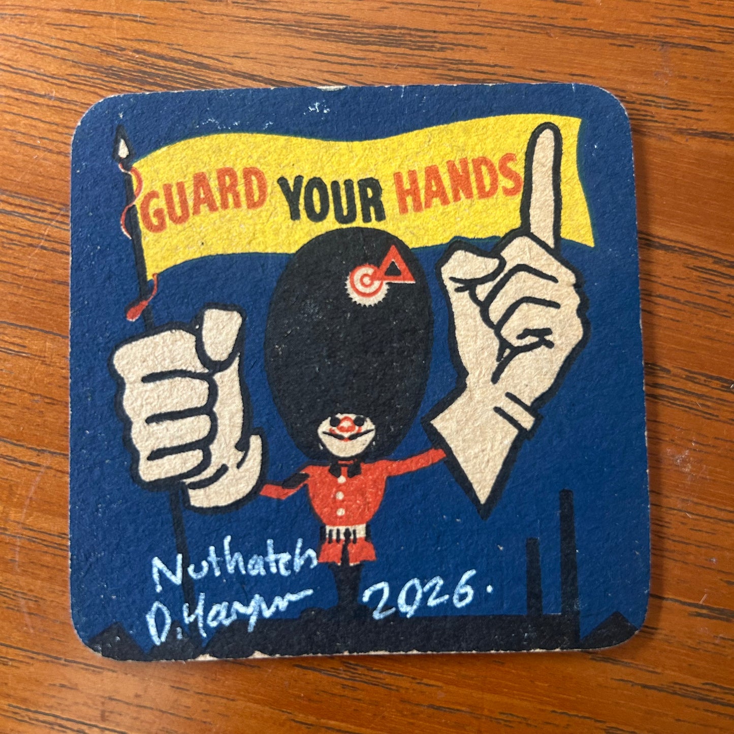 A Nuthatch painted onto a ‘Guard Your Hands’ drinks mat from the 1950s. Beermat painting. Watercolour.