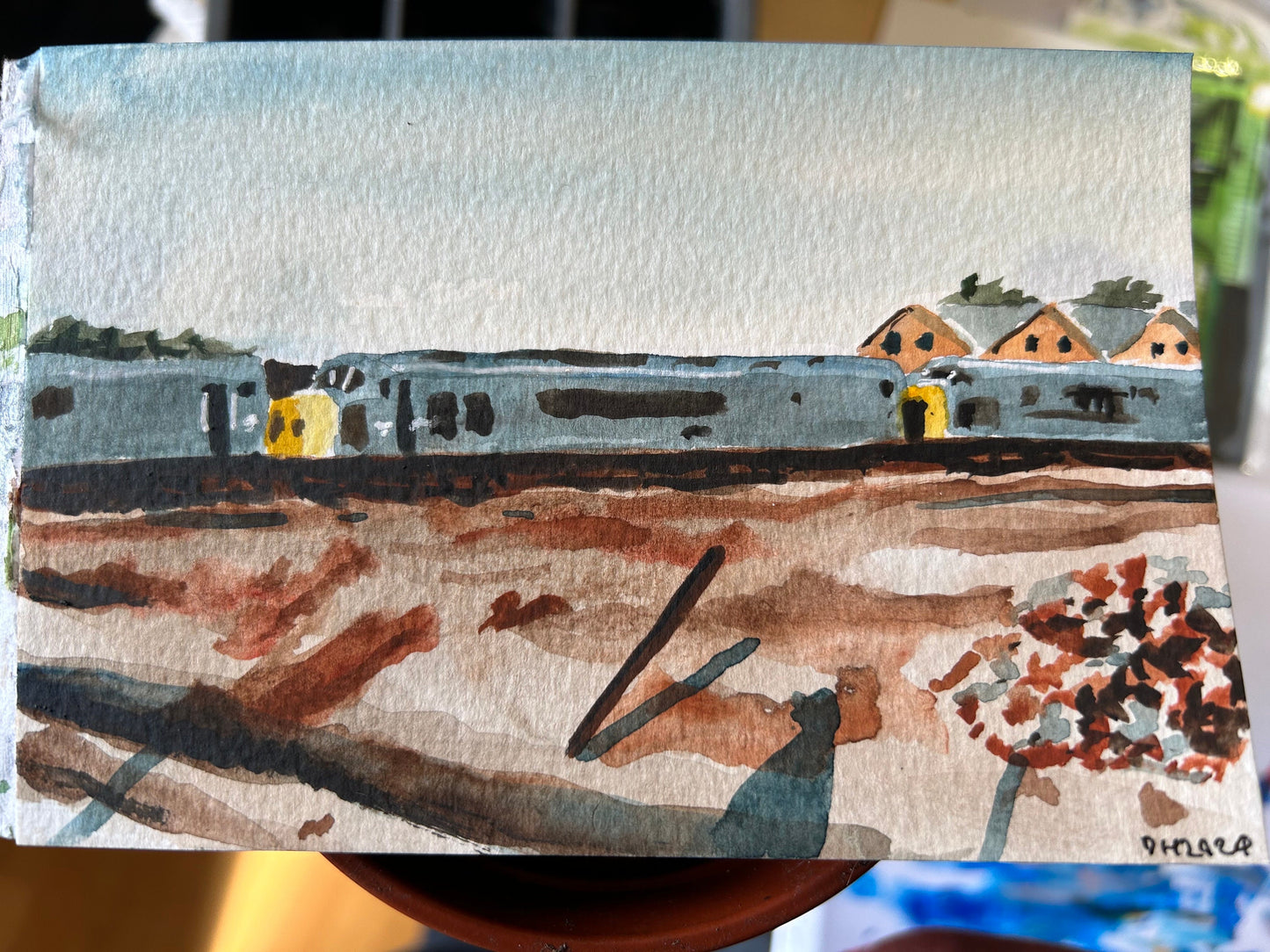 Postcard painting of a row of derelict diesel trains. From a childhood photograph by Kevin Griffiths.