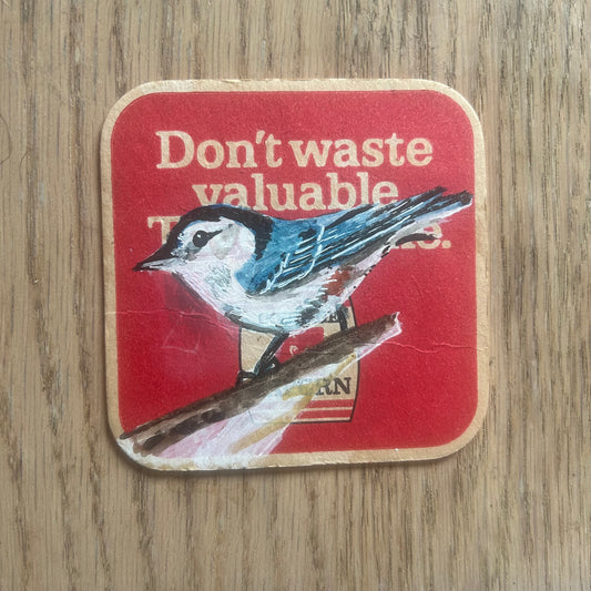 White breasted Nuthatch painted onto a Tavern beer mat from the 1960s. Beermat painting. Watercolour.