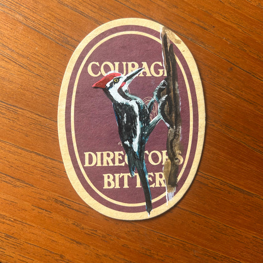 A Woodpecker painted onto a Courage beer mat. Beermat painting. Watercolour.
