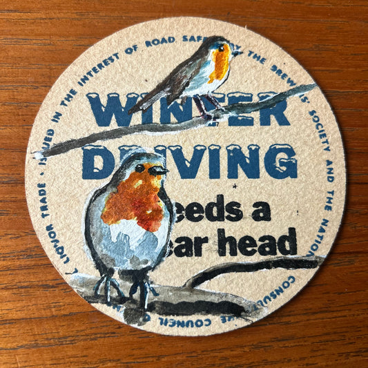 Two Robins painted onto a 1960s ‘Winter Driving’ Beer mat. Beer mat painting. watercolour and acrylic on card.