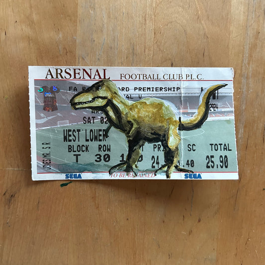 A dinosaur painted onto a football ticket Match ticket - Arsenal v Southampton 02/02/2002 Premiership- Watercolour. Ticket has a crease in it.