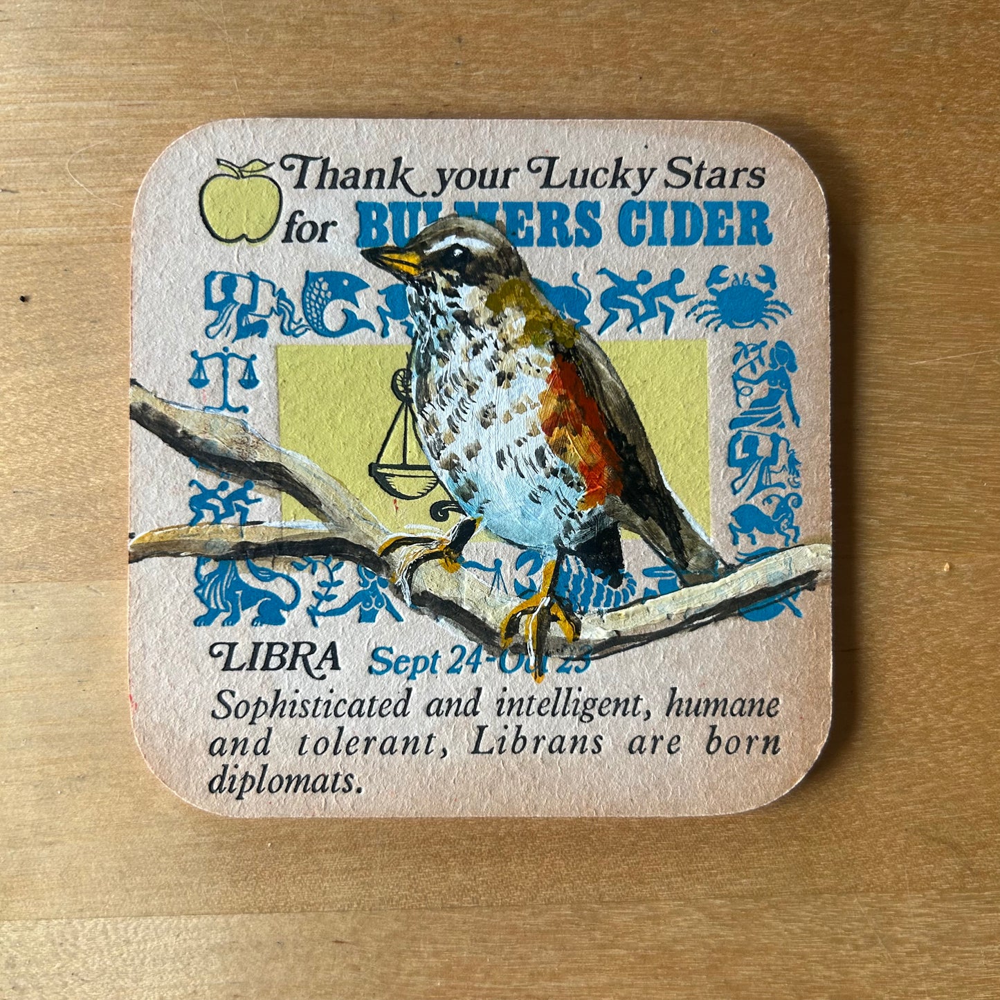 A Redwing painted onto a 1970s Bulmer’s Cider Zodiac drinks mat (Libra). Beermat painting. Watercolour.