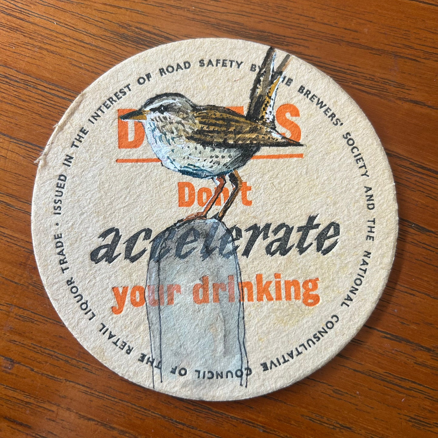 A Wren painted onto a ‘Drivers Don’t Accelerate Your Drinking’ drinks mat from the 1950s. Beermat painting. Watercolour.