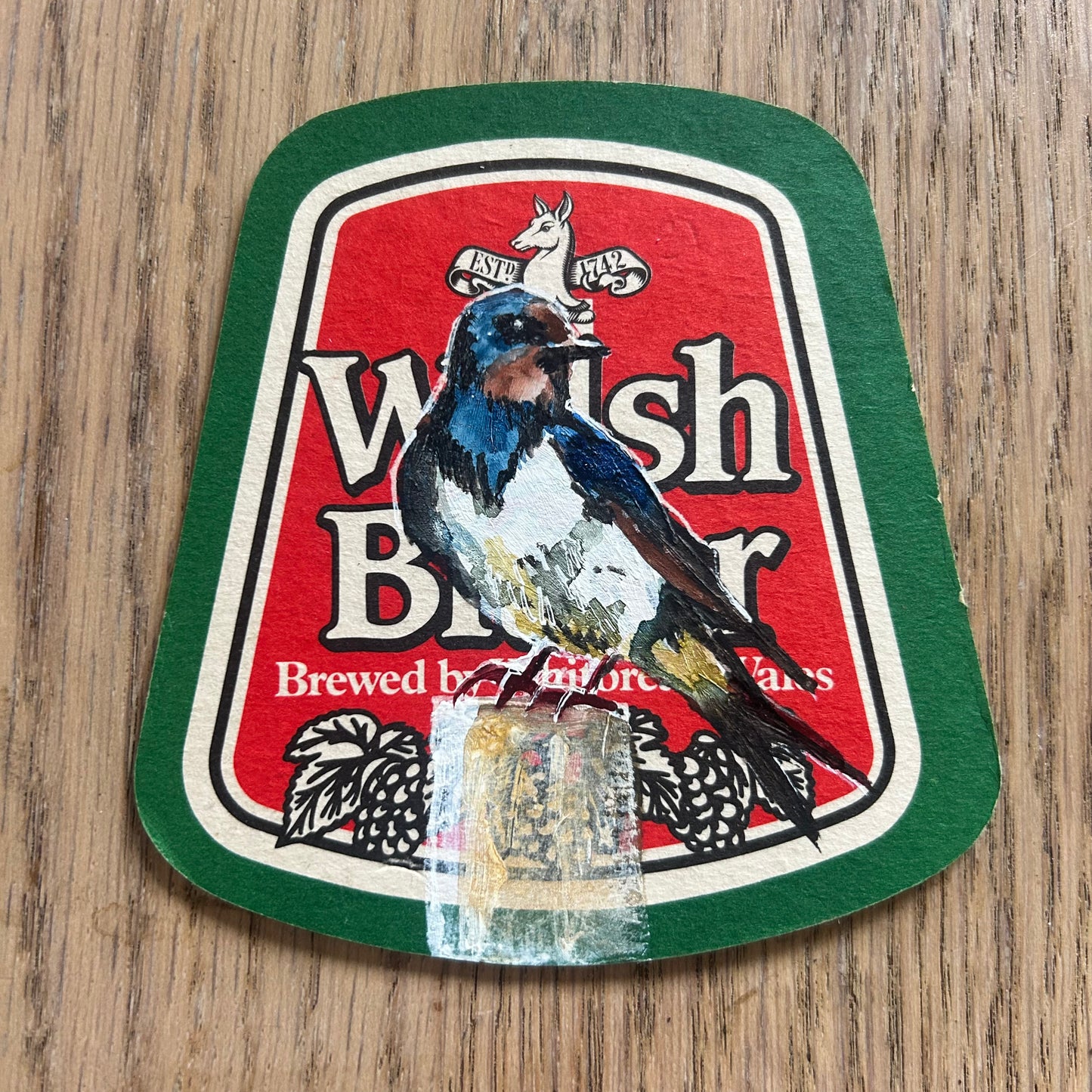 A Swallow painted onto a Welsh Beer drinks mat.  Beermat painting. Watercolour.