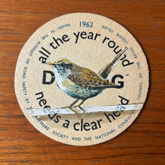 A Wren painted onto a ‘’All The Year Round Driving” 1962 beer mat. Beer mat painting. watercolour and acrylic on card.