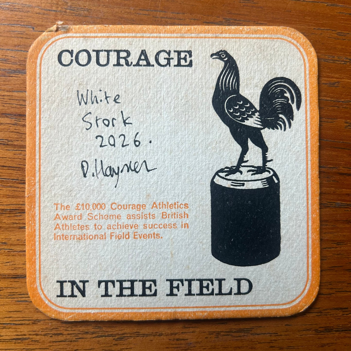 A Stork painted onto a Courage Beer ‘In The Field’ Athletics beer mat from 1964. Beermat painting. Watercolour.