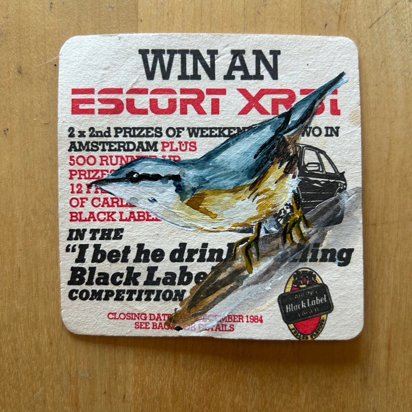 A Nuthatch painted onto a ‘Win an XR3i’ Carling Black Label drinks mat from the 1980s. Beermat painting. Watercolour.