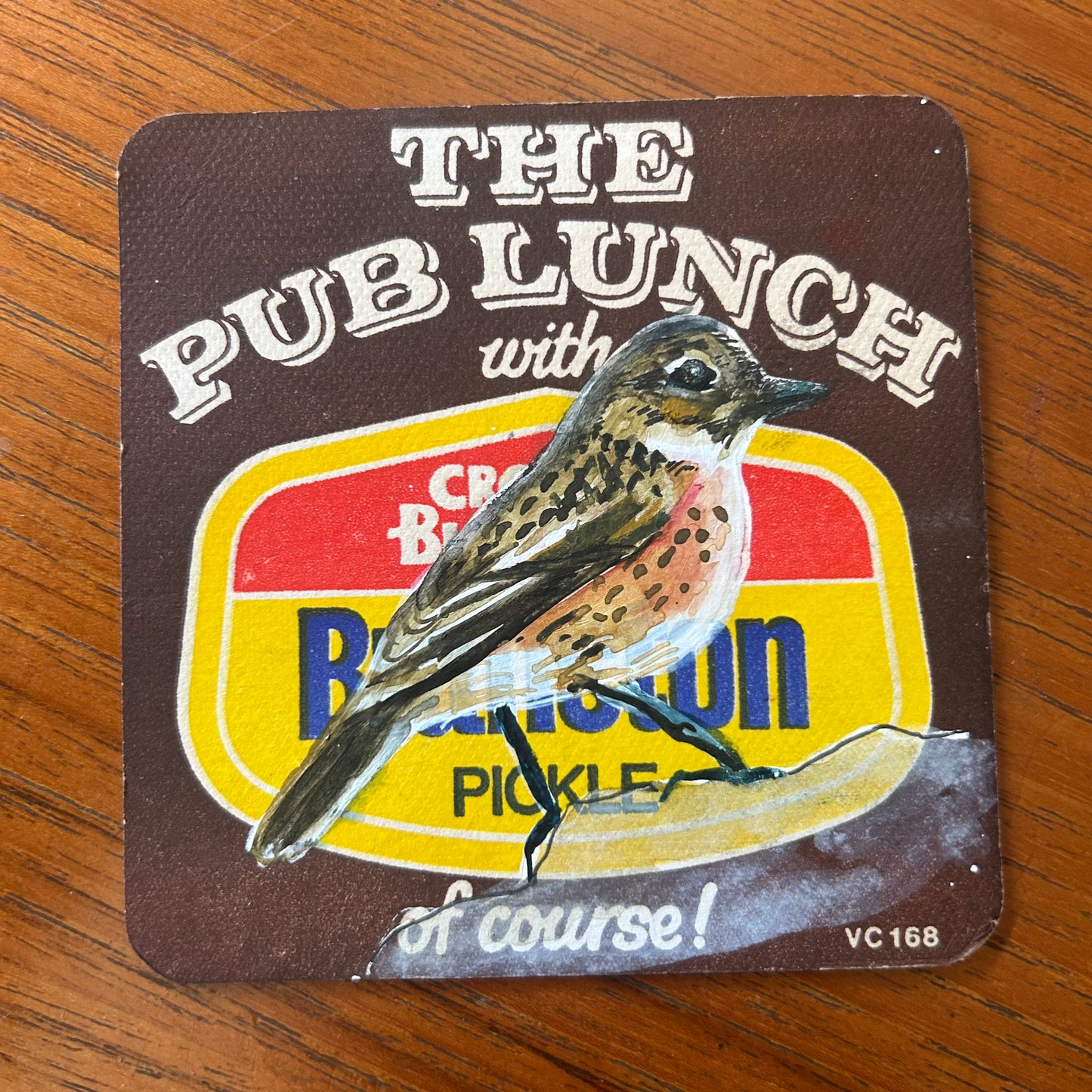 An Eurasian Stone Chat painted onto a Branston Pickle Beermat painting. Watercolour.