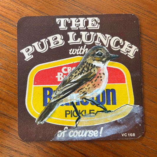 An Eurasian Stone Chat painted onto a Branston Pickle Beermat painting. Watercolour.