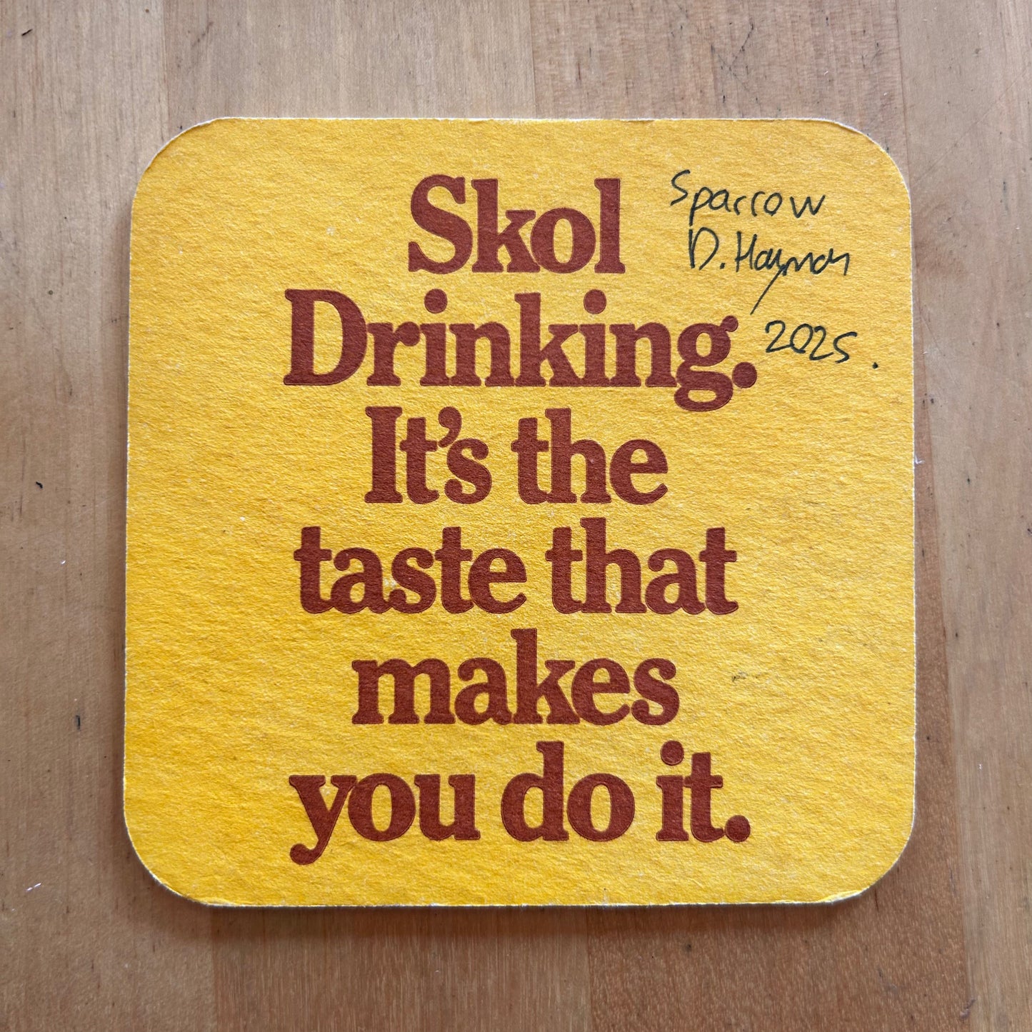 A Sparrow painted onto a Skol beermat. Beermat painting. Watercolour.