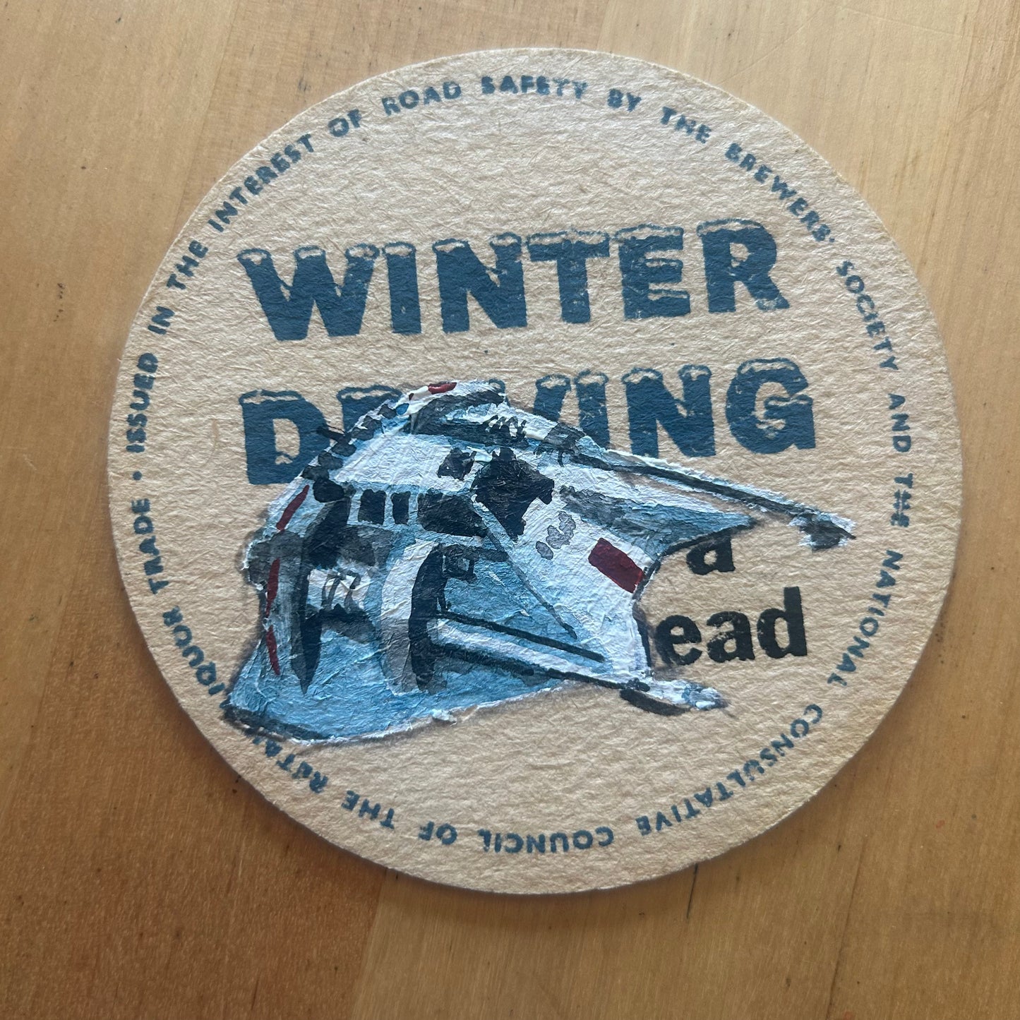 A Snowspeeder painted on a ‘Winter Driving’ Beermat from the 1950s. Beermat painting. Watercolour.