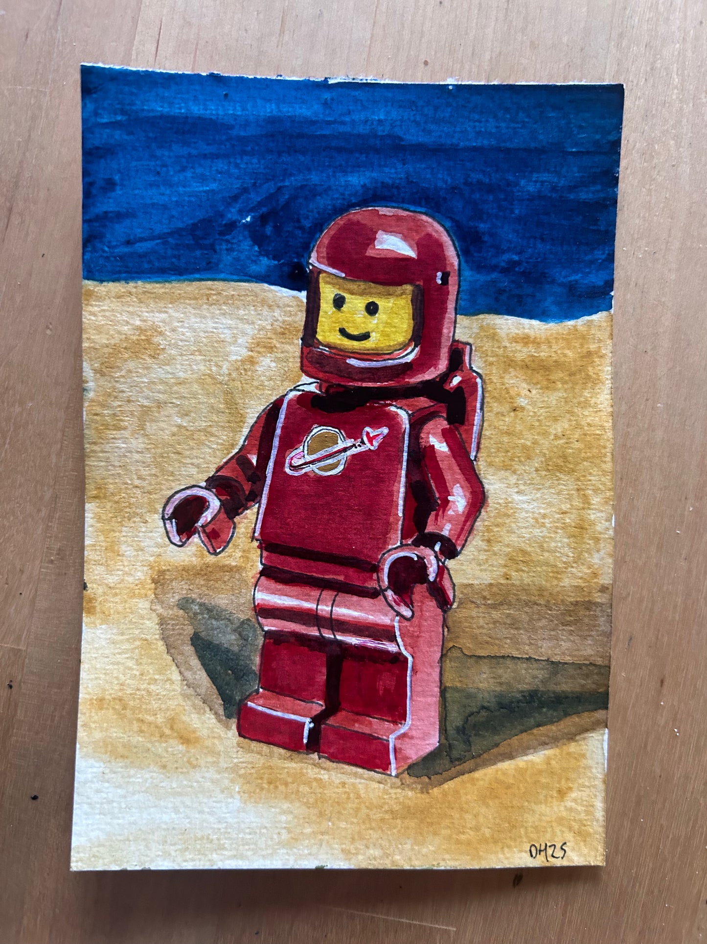 ‘Reset Horizons’ Postcard painting of a Lego Spaceman figure 1978.